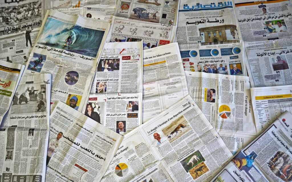 Home A variety of Arabic newspapers laid out, showcasing cultural and news diversity in Fès, Morocco.