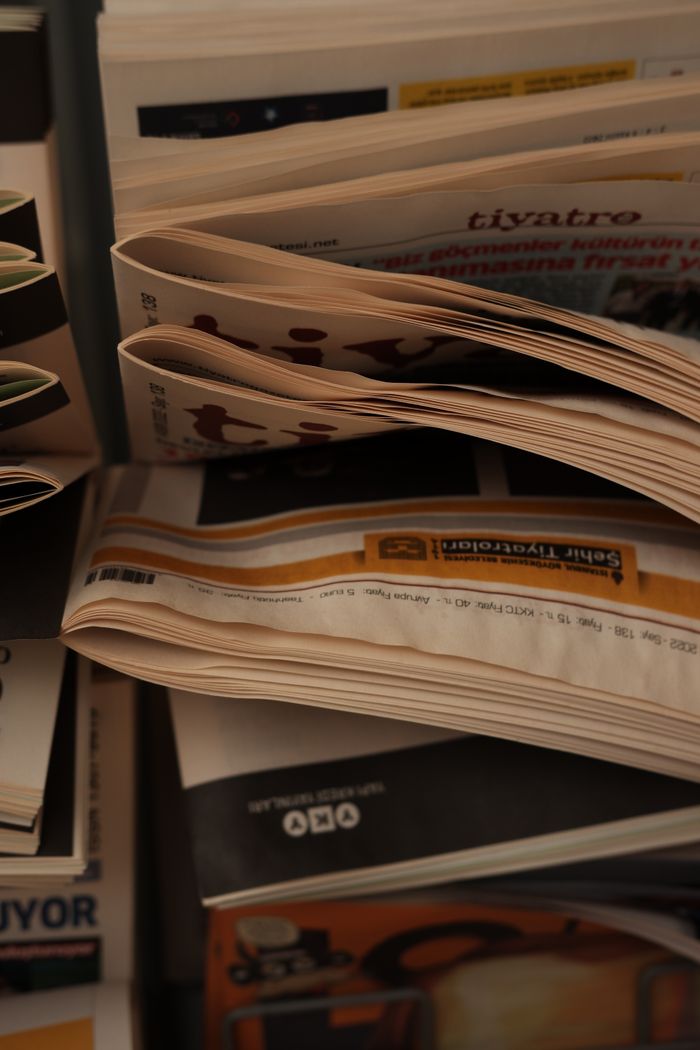 Home Close-up view of folded newspapers in a rack with multiple headlines visible.